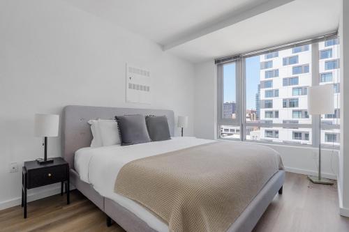 a white bedroom with a large bed and a large window at SoMa 1br w roofdeck gym pet area nr groceries SFO-1430 in San Francisco