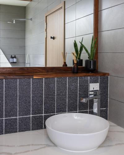 a bathroom with a white sink and a mirror at Villa Mia Fulhadhoo in Fulhadhoo