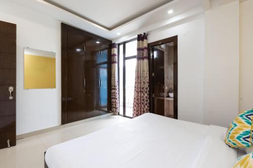 a bedroom with a white bed and a window at Daisy by Wabi Sabi Stays with Private balcony in Rishīkesh