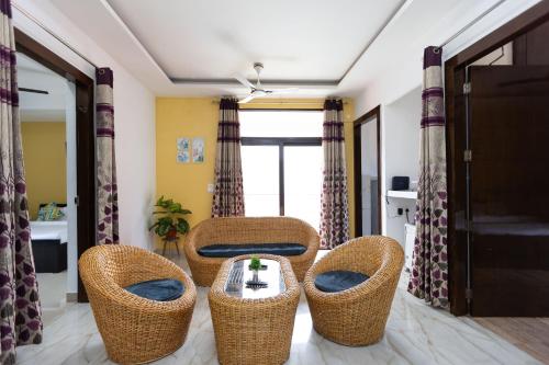 a living room with wicker chairs and a table at Daisy by Wabi Sabi Stays with Private balcony in Rishīkesh