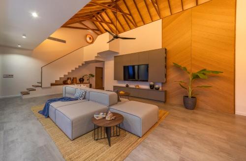 a living room with a bed and a tv at Villa Mia Fulhadhoo in Fulhadhoo