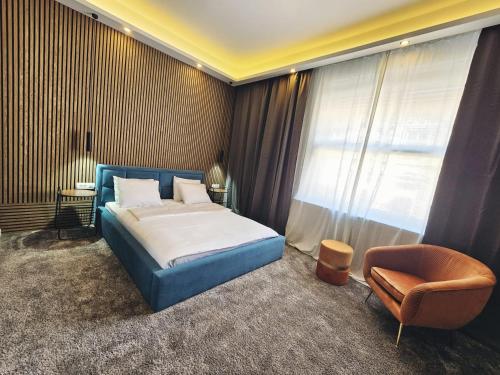 um quarto com uma cama, uma cadeira e uma janela em B&B Cvjetni em Zagreb