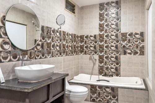 y baño con lavabo, aseo y espejo. en Skon Morjim Beach Resort by Orion Hotels, en Morjim