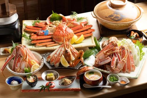 a table topped with lots of different types of food at 一日一組の隠れ宿　てらかわ in Kinosaki