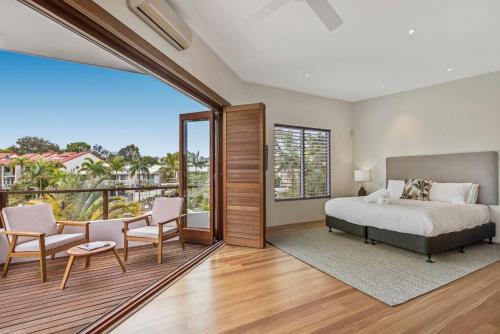 a bedroom with a bed and a balcony at 14 Cooran Court in Noosa Heads
