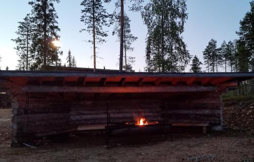 a log cabin with a fire in it at Villa Kanger Ruka 2 in Kuusamo