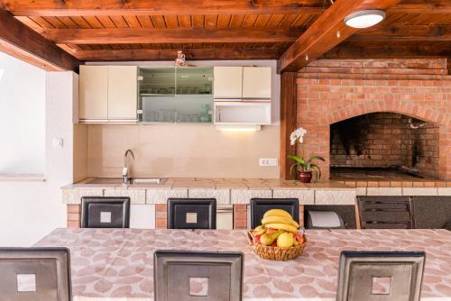 a kitchen with a table with a basket of fruit at Apartmani Katica in Povile
