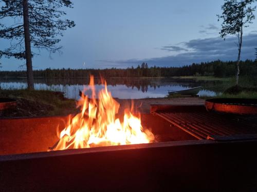 a fire pit in front of a lake at Villa Kanger Ruka 2 in Kuusamo