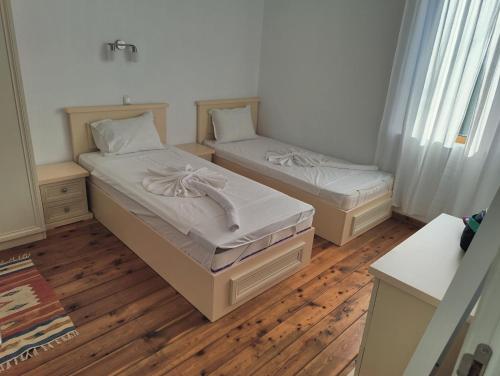 two beds in a room with wooden floors at Villa Shelly whith private pool in Lozenets