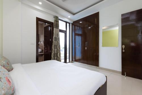 a bedroom with a white bed and a window at Lily 3BHK by Wabi Sabi Stays with Private Balcony in Rishīkesh