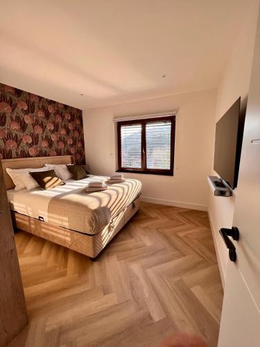 a bedroom with a bed and a flat screen tv at The Penthouse Sarajevo in Sarajevo