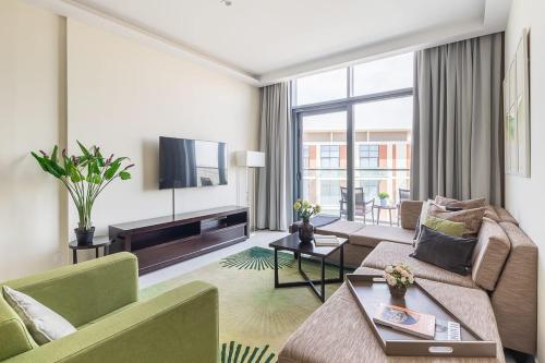 a living room with a couch and a tv at Frank Porter - Damac Celestia in Dubai