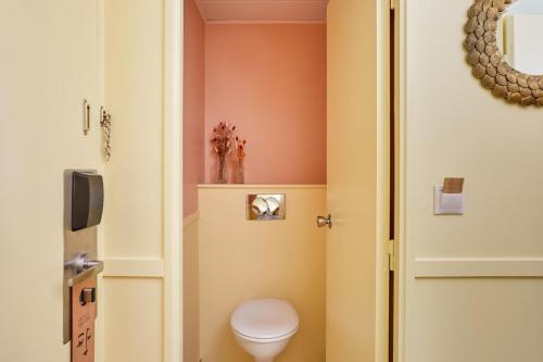 a bathroom with a toilet next to a door at Hotel Indigo Bordeaux Centre Chartrons by IHG in Bordeaux