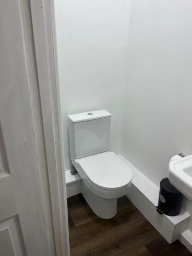a white bathroom with a toilet and a sink at Nice and Pleasant in Thornton Heath