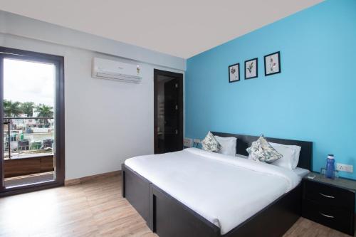 a bedroom with a large bed with a blue wall at Jasmine 3BHK by Wabi Sabi Stays with Private Balcony in Rishīkesh