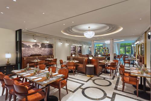 a restaurant with tables and chairs in a room at ITC Narmada, a Luxury Collection Hotel, Ahmedabad in Ahmedabad