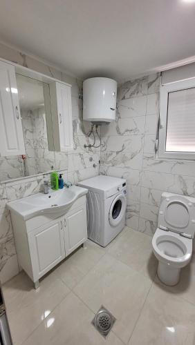 a white bathroom with a washing machine and a washer at Montenegro apartments Phoenix in Bar, Susanj