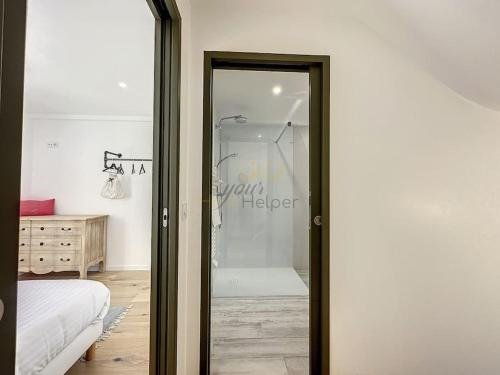 um quarto com uma porta de vidro que leva a um chuveiro em La Deauvilloise YourHostHelper em Deauville