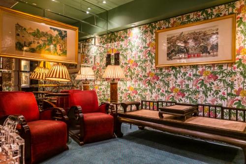 a waiting room with red chairs and floral wallpaper at Lan Kwai Fong Hotel - Kau U Fong in Hong Kong