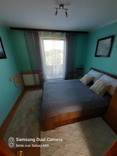 1 dormitorio con 1 cama grande y ventana en Kuca za odmor Vinica breg en Varaždin