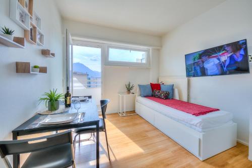 a bedroom with a bed and a table and a dining room at Cosy Home Lugano Few Min From Lake - Happy Rentals in Lugano