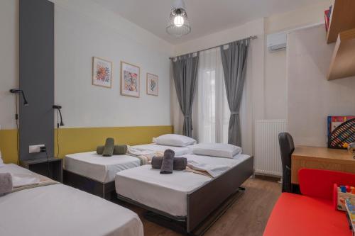 una camera con tre letti e una finestra di Estia Thessaloniki Apartment, cozy, spacious, sunny, 2 rooms-5 beds a Salonicco