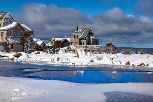 a snow covered town with houses and a river at Cascade - Dinner Plain in Dinner Plain