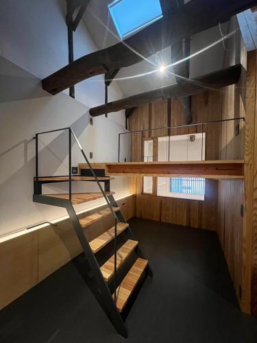 a spiral staircase in a room with wooden walls at ゲストハウス　遊楽２F in Osaka