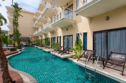 a swimming pool in the middle of a building at The Front Village - SHA Plus in Karon Beach