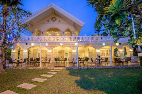 an exterior view of a house with tables and chairs at The Front Village - SHA Plus in Karon Beach