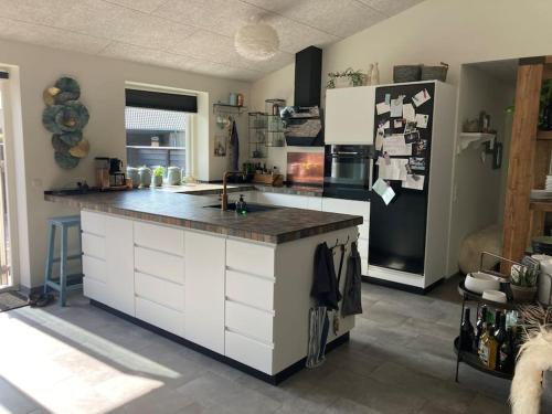 eine Küche mit einer Arbeitsplatte und einem Kühlschrank in der Unterkunft Hyggeligt hus. in Holstebro