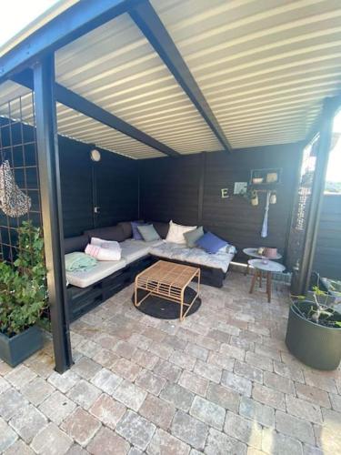 a patio with a couch and a table at Hyggeligt hus. in Holstebro