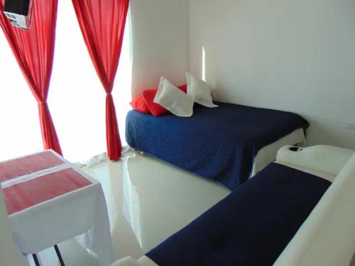 a small room with two beds and a window at Departamentos Villas Capdeviel in Cancún