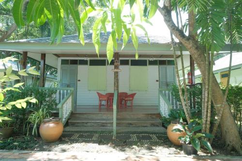 een veranda van een huis met een tafel en stoelen bij Baan Imm Sook Resort in Chao Lao Beach