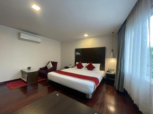 a hotel room with a bed and a window at 37th Crescent Hotel Bengaluru in Bengaluru