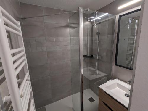 ein Bad mit einer Dusche und einem Waschbecken in der Unterkunft Ecrin Alpe d'huez in Huez
