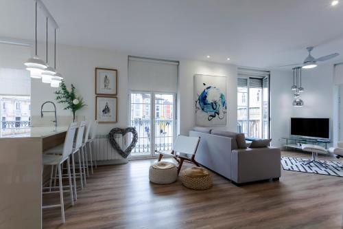 uma sala de estar e cozinha com um sofá e uma mesa em Cinco balcones a la Catedral by Unique Rooms em Burgos