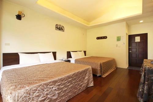 - une chambre d'hôtel avec 2 lits et une porte dans l'établissement 後頭厝民宿, à Guoxing