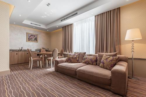 a living room with a couch and a table at Maidan Palace Hotel in Kyiv