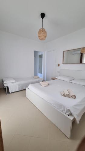 um quarto branco com 2 camas e um espelho em Lotto 16 em Olbia