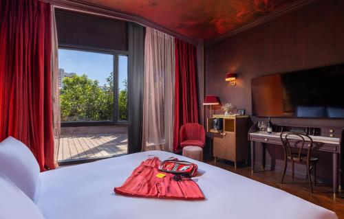 a hotel room with a bed with a red cape on it at Play Levontin in Tel Aviv