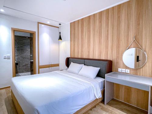 a bedroom with a large white bed and a mirror at Happy Villa Hạ Long in Ha Long