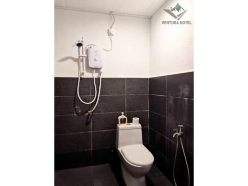 a bathroom with a toilet and a shower at Ventura Hotel and Tours in Gua Musang