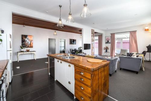 a kitchen and living room with a sink and a couch at Altitude Apartment, Martinborough in Martinborough 