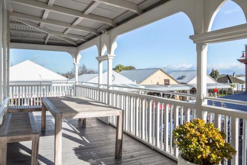 a porch with a wooden table and a bench at Altitude Apartment, Martinborough in Martinborough 