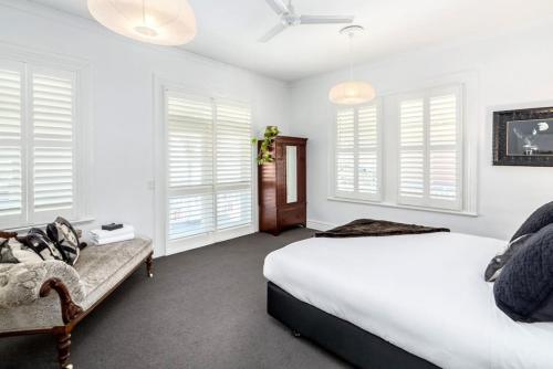 a bedroom with white walls and windows and a bed at Altitude Apartment, Martinborough in Martinborough 