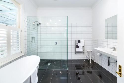 a white bathroom with a tub and a sink at Altitude Studio Apartment in Martinborough 