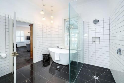 a bathroom with a tub and a glass shower at Altitude Studio Apartment in Martinborough 