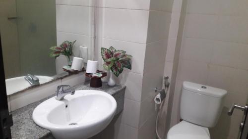 La salle de bains est pourvue d'un lavabo, de toilettes et d'un miroir. dans l'établissement The Agung Residence, à Seminyak