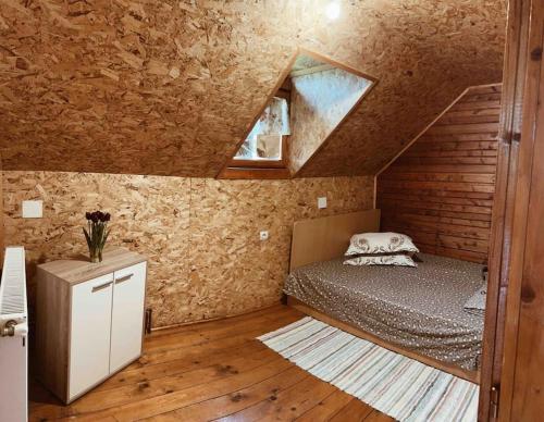 a small bedroom with a bed in a attic at Cabana Oana 5-bedrooms chalet in Arad